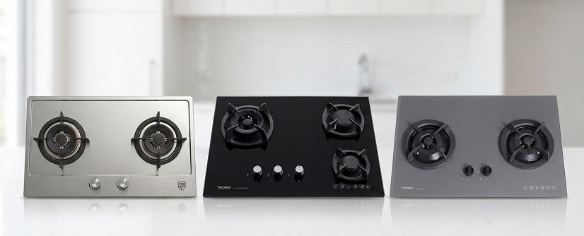 A row of gas cooker hobs in stainless steel and tempered glass